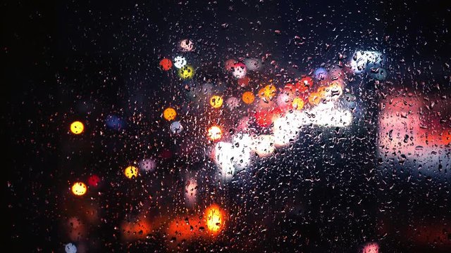 rain drop at glass window with street traffic background