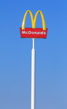V&auml;ster&aring;s, Sweden - July 5, 2013:: Pole with a sign and McDonald's logo on a clear blue sky at H&auml;lla mall.