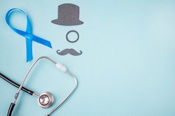  Light blue ribbons with black mustache, top hat and stethoscope on blue background, prostate cancer awareness, Movember Men health awareness, November blue. copy space.