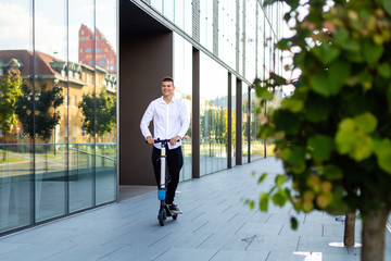 Young and casual business man riding electric scooter in the city © 24K-Production