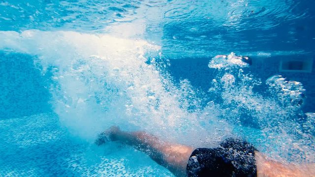 Slow motion of men head jump in a pool