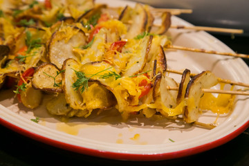 Potato chips with cheese and peppers on skewer
