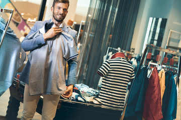 Handsome sexy elegant man choosing shirt