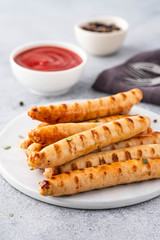 Grilled sausages on light background. Copy space.