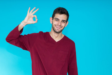 isolated young man with approval expression in color background