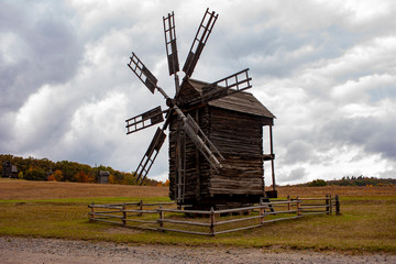 Wooden mill. Cloudy autumn day in a countryside mill village. Autumn rural landscape