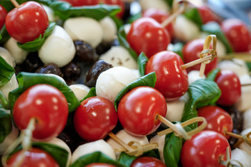 cocktail snack with cherry tomatoes, basil and black olives