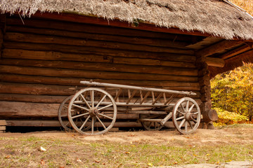 Fototapeta na wymiar Old wooden cart in front of an old barn. Rural landscape