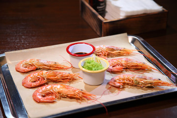 Langoustines with sauce on a tray.