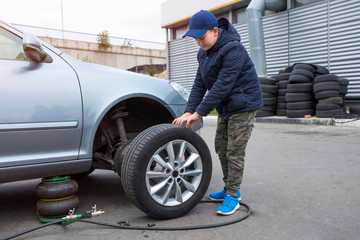 Children's mechanic to replace the wheel tires and service the vehicle suspension. The concept of repair.