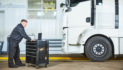Truck repair service. Mechanic makes computer diagnostic of the semitruck