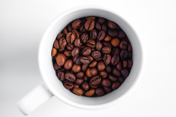 Bright grains of coffee in a glass, top view.