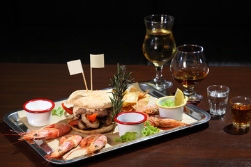 Burger and langoustines with sauce on a tray.