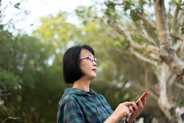 Asian mature woman using cellphone