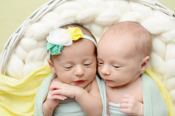 The sleeping Newborn gilr and boy lies in busket. Newborn twins