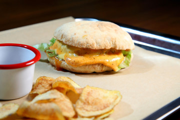 Burger with meat and vegetables. Hot burger in a burning sauce. Double cheese burger.