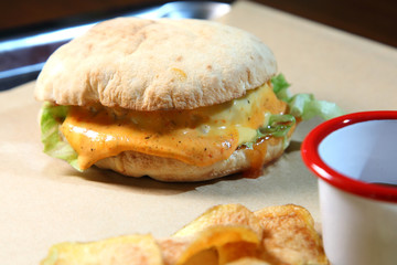 Burger with meat and vegetables. Hot burger in a burning sauce. Double cheese burger.