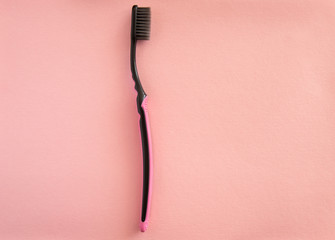 Toothbrush for brushing teeth on pink background, pastel colors