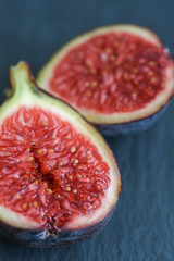 Close-up of a purple fig with red and bright interior on black background