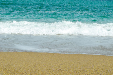 Blue ocean Sea wave with white foam close-up. Sandy beach. Copy space. Selective focus image. Sea beach backdrop. Summer holiday concept.