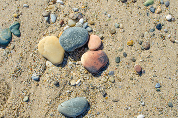 Fototapeta na wymiar Pebble beach. Small colored sea stones close-up. Multicolor seabed. Selective focus image, copy space. Sea beach backdrop. Summer holiday concept.