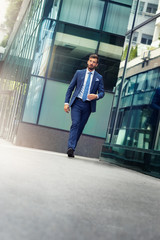 Fototapeta premium Handsome businessman dressed in suit walking