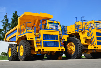 Heavy-duty trucks warehouse at autoworks. Big mining dump truck manufacture by the heavy vehicle plant. Coal mining, granite, gravel, sand.