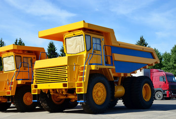 Heavy-duty trucks warehouse at autoworks. Giant mining dump trucks manufacture by the heavy vehicle plant. Heavy quarry equipment. Coal mining, granite, gravel, sand.