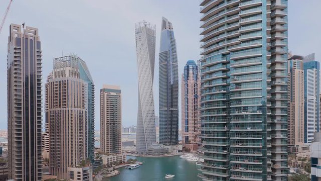 Aerial paniramic view of Dubai Marina residential and office skyscrapers with waterfront. Floating boats and yachts
