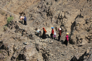 Children and women walk rugged mountain paths due to war and siege in the Yemeni city of Taiz