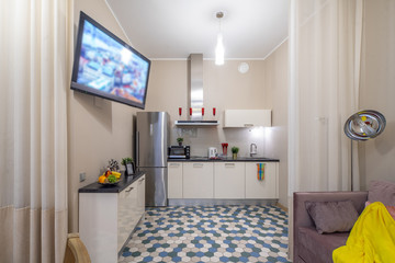 Modern interior of light studio apartment. Living room and kitchen.