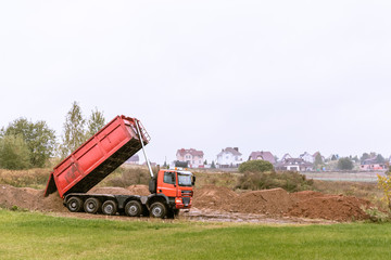 A large 70-ton dump truck brought sand to a new construction site to add land