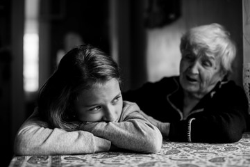 Little girl sad and grandmother soothes her. Black and white photo.
