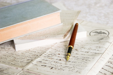 fountain pen on old blank papers in front of books