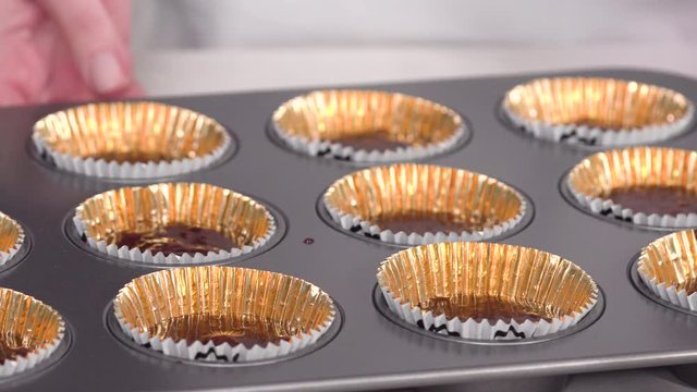 Step by step. Scooping batter with a cupcake scoop to make unicorn chocolate cupcakes with buttercream frosting.