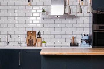 Kitchen with white tiles and dark furniture