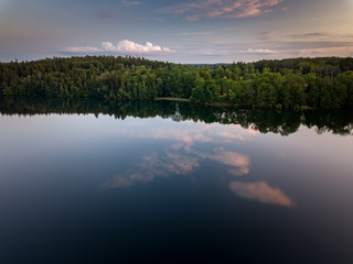 Clouds reflect in a perfectly still lake on a calm summer evening