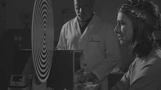 Scientist hypnotizing a woman in a scientific lab