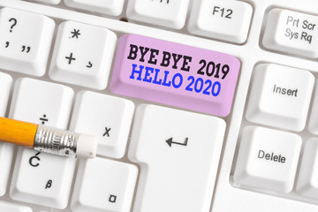 Word writing text Bye Bye 2019 Hello 2020. Business photo showcasing Starting new year Motivational message 2019 is over White pc keyboard with empty note paper above white background key copy space © A