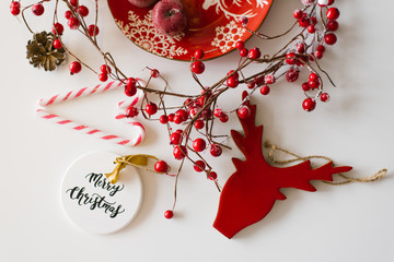 Christmas and new year card in red and white. Christmas decorations, red berries and candies