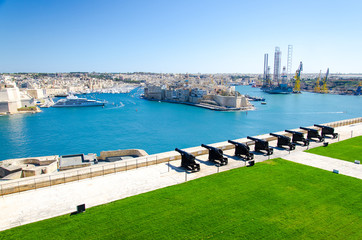 Valletta, Malta - March 11, 2017: Saluting Battery of Cannons at the Fort Lascaris St. Angelo of La Vittoriosa upper Barrakka gardens view to the port and Grand Harbor