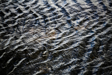 An abstract close up photo of the ripples in a river created by a wave. Perfect for background use