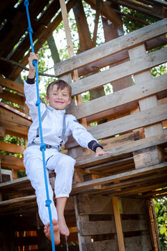 Young boy as a superhero, astronaut playing in a tree house