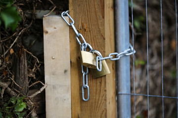 A fence that has been chained and locked with a padlock to keep people out and to keep property safe