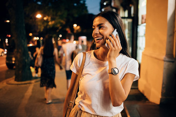 Young woman using smartphone in the city at night