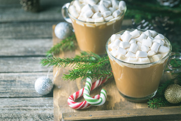Obraz na płótnie Canvas Two Glass cups of cocoa with marshmallow on a wooden background with christmas decorations