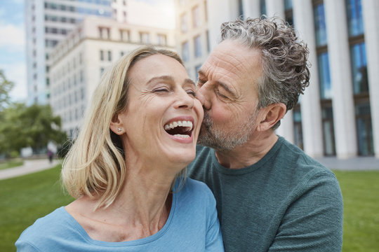 Happy mature, couple kissing in the city