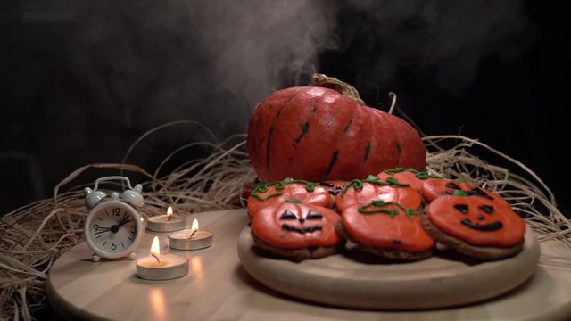 Spooky Halloween Decoration Scene With Cookies, Pumpking, Candles and Watch, Slow Motion. All Saints Eve America Celebration October 31st