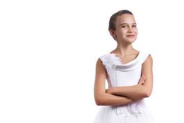 Little beautiful European girl with a slight smile on her face in a white dress crossed her arms over her chest and looks at the camera isolated on white background. Copy space for text.
