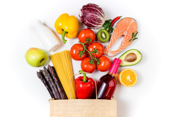 Shopping healthy food concept. Healthy food in paper bag fish salmon, pasta, vegetables, fruits and wine on white background. Shopping food supermarket, healthy food concept. Top view